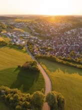 View of a village and a road surrounded by fields and trees at sunset, Gechingen, Black Forest,