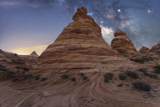 Scenic view of striking rock formations with swirling patterns under a mesmerizing starry night