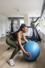 Businesswoman maintaining her workout routine while traveling, performing squats with a fitness