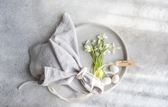 Top view of a decorative spring setup featuring a cluster of fresh snowdrops in a ceramic plate,