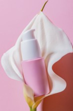 A striking image of a sleek and modern pink cosmetic dispenser nestled within the tender folds of a