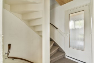 A minimalist indoor staircase with a modern design featuring light colored walls, a wooden