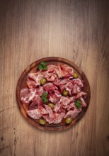 Assortment, sliced meat appetizer, prosciutto, salami and ham, with olives, on a wooden board,