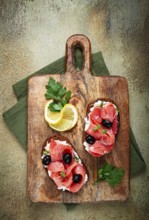 Sandwiches with cream cheese, chum salmon, cold smoked, grain bread, on a cutting board, top view,