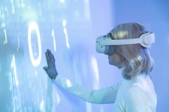 An elderly Asian woman interacts with the virtual world wearing a VR headset, symbolizing the