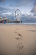 Footprints in the sand to the Ferris wheel at the pier, The Hague, Netherlands