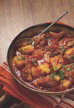 Potatoes with meat, stewed in tomato sauce, with spices and herbs, homemade, no people
