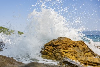 Wellen brechen an einem Felsen im Meer an einem sonnigen Tag auf der Insel Cres, Kroatien