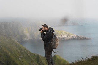 A traveler captures breathtaking views of Norway's rugged coastline Adventure, exploration, and