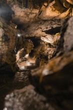 A mysterious cave trail with dramatic lighting and rock formations, St. Beatus Caves, Switzerland