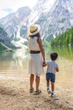 Mother and son admiring stunning panorama of lake braies, surrounded by majestic mountains and lush