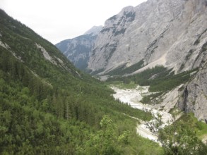 Extensive view of a wooded valley with a meandering river, hiking through the Reintal valley to the