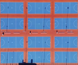 From above, this image captures a series of neatly arranged netball courts in the heart of