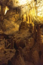 Stunning cave formations illuminated by warm lights, showcasing the beauty of nature's artistry in