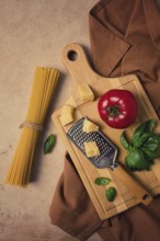 Raw pasta with ingredients on a beige background, top view, rustic style, selective focus, no