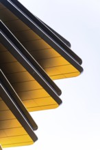 Abstract view of modern architectural design featuring striking golden panels set at angles against