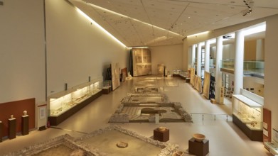 Long room in the museum with archaeological artifacts and well-lit display cases, Patras