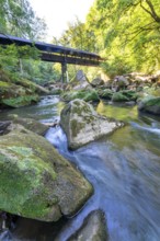 The Irrel Waterfalls, rapids in the lower reaches of the Prüm, covered wooden bridge for hikers,