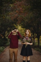 A couple enjoying a beautiful fall day in Quebec, Canada. The woman holds a bouquet of wildflowers,