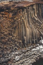 Stunning basalt columns at Studlagil Canyon, Iceland, display intricate geological formations. This