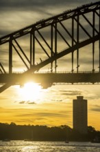 Tourists climbing Sydney harbour bridge at sunset, Sydney, New South Wales, Australia