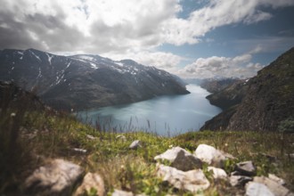 A breathtaking view of a serene turquoise lake nestled between rugged mountains in Norway The