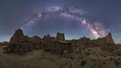 Stunning view of the Milky Way arching over a rugged sandstone desert landscape in Utah, USA. The