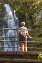 A woman at the top of the Todtnau waterfall in the Black Forest in Germany