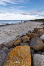Coastal defence, boulders with view on sandy beach, dusk, Carne Beach, Wexford, Gerrans Bay,