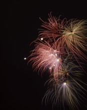 Red, blue and yellow fireworks bursts in night sky, Montreal International Fireworks Festival,