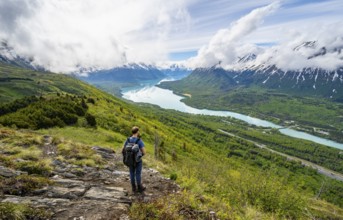 Climbers on a hiking trail, Slaughter Ridge Trail, view of snowy mountains and turquoise lake Kenai