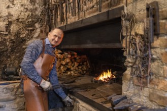In a Salzburg workshop, an elderly blacksmith diligently upholds age-old blacksmithing traditions.