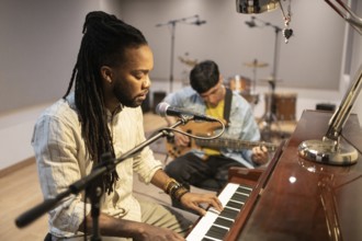 Musicians engage in an inspiring recording session with a pianist and guitarist in a professional