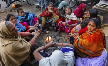 New Delhi, India, 15.01.10 - Women warm up by a fire at the market in New Delhi, India