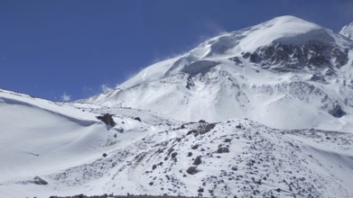 Snowy mountain landscape under clear blue sky, Thorong La, Manang, trekking at Annapurna Circuit,