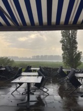 Thunderstorm and raindrops on a terrace of a restaurant on the Rhine in Düsseldorf, Germany