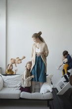 A joyful family scene with a mother and four children playing in a cozy living room The children