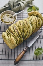 Baked homemade savoury babka plaited bread loaf flavoured with pesto