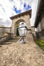 Historic stone arch with staircase and lantern in the foreground, Lake Brienz, Switzerland