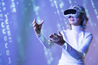 Elderly Asian woman wearing a virtual reality headset, interacting with the digital elements of the