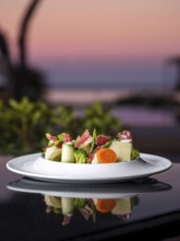 A beautifully arranged gourmet salad with ham featuring fresh vegetables and cheese. The elegant