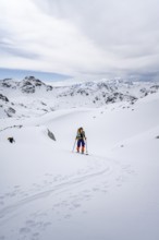 Ski tourer in mountain landscape with snow, ascent to Grialetsch Scharte, Bündner Haute Route,
