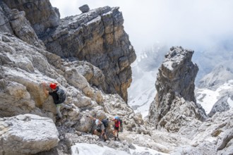 Three hikers climb the Cima falconer mountain peak, Brenta Mountains, Brenta, Brenta-Adamello