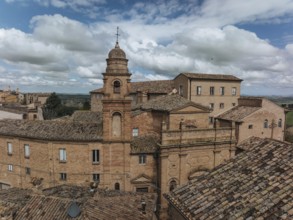 Historic buildings in Treia, Italy, showcase classic architecture with terracotta roofs under a