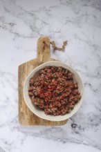 Raw minced meat, marinated with spices and herbs, in a bowl, minced meat with spices, top view,