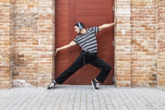 A cuban dancer exudes creativity and style, striking a dynamic pose against a vibrant red door