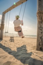 Tourist on the beach on a swing, Zandvoort, Netherlands