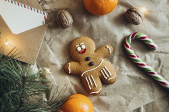 A charming gingerbread man cookie surrounded by holiday elements like a candy cane, nuts,