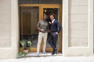 Two professionals smiling in front of a coworking space in Barcelona, showcasing a modern and
