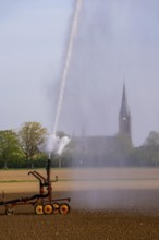 Artificial irrigation of a field, freshly sown, in April, with a sprinkler system, long drought in